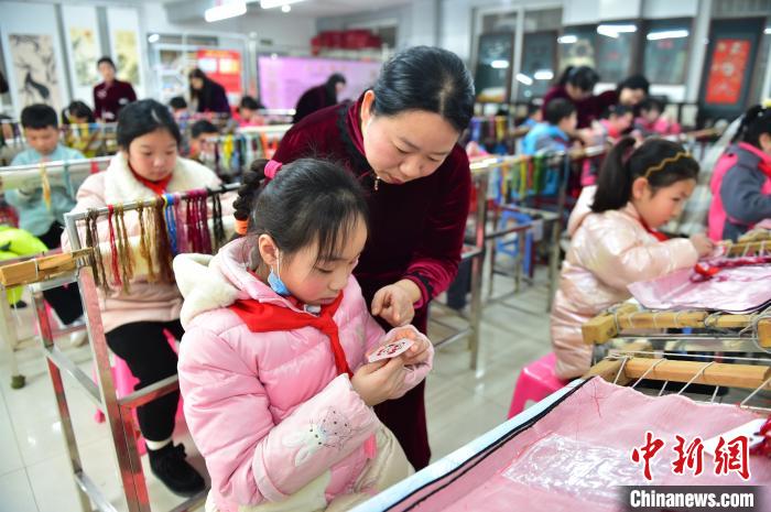 江西省級非遺豫章繡傳承人手把手指導小學生繡制2022年北京冬奧會吉祥物“冰墩墩”形象?！∮髟屏?攝