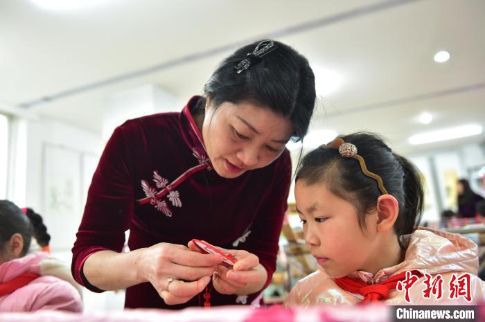 江西省級非遺豫章繡傳承人手把手指導小學生繡制2022年北京冬奧會吉祥物“冰墩墩”形象?！∮髟屏?攝