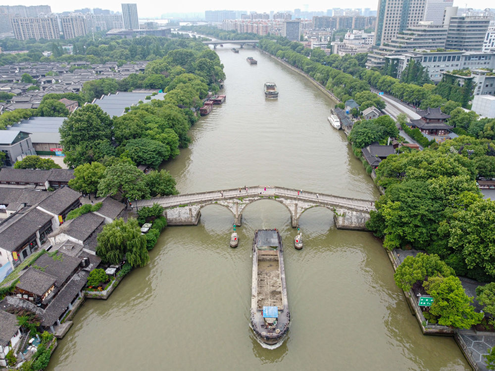5月27日，一艘貨船駛過京杭大運(yùn)河南端標(biāo)志建筑杭州拱宸橋。(無人機(jī)照片)新華社記者江漢 攝