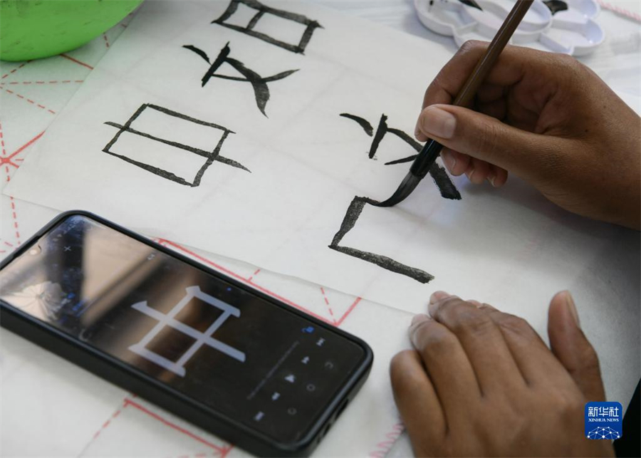 4月18日，肯尼亞學(xué)生在內(nèi)羅畢大學(xué)孔子學(xué)院舉辦的活動上寫毛筆字?？夏醽唭?nèi)羅畢大學(xué)孔子學(xué)院18日舉辦“中文，增進(jìn)文明對話”主題活動，慶祝即將到來的第14個聯(lián)合國中文日?？夏醽唽W(xué)生參與互動，進(jìn)行書法、剪紙、唱中文歌等活動。新華社記者 韓旭 攝
