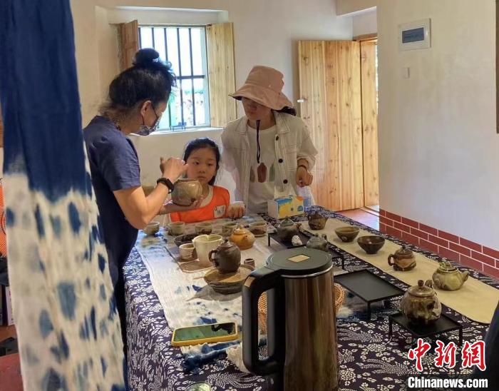 圖為：游客正在咨詢臺(tái)灣柴燒作品?！∪~秋云 攝