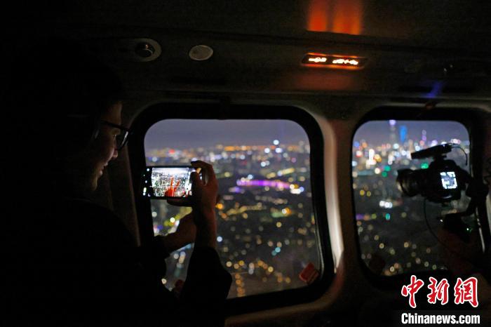 6月3日晚，游客乘坐上海新空直升機(jī)有限公司直升機(jī)開啟鳥瞰黃浦江空中圓夢之旅，并用手機(jī)拍攝城市夜景?！∫罅⑶?攝