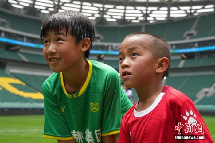 圖為北京國安小球員陳小北和7歲的俄金仁增在一起觀看場內(nèi)播放的紀錄片。<a target='_blank' href='/' _fcksavedurl='/'><p  align=