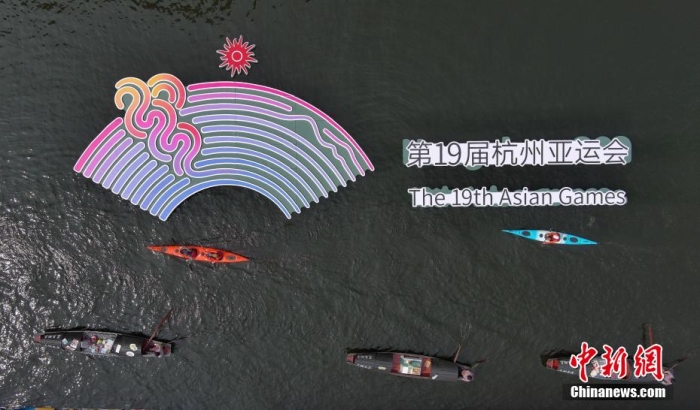 資料圖為烏篷船和皮劃艇從杭州亞運會標(biāo)識前劃過。王剛 攝