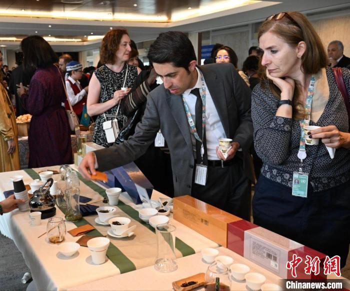現(xiàn)場(chǎng)觀眾觀看中國(guó)展臺(tái)茶藝表演、了解茶文化?！【笜?攝