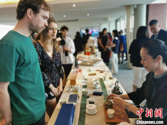 現(xiàn)場(chǎng)觀眾觀看中國(guó)展臺(tái)茶藝表演、了解茶文化。　靖樹 攝