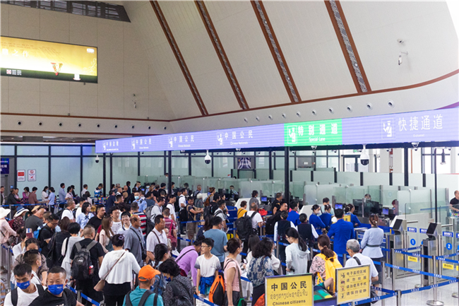 7月22日，乘坐中老鐵路國際旅客列車的旅客在磨憨邊檢大廳排隊候檢。衛(wèi)海林 攝