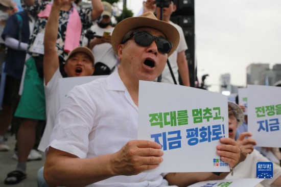 7月22日，在韓國首爾，人們手舉標(biāo)語參與反戰(zhàn)游行。新華社發(fā)（楊暢 攝）