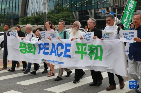 7月22日，在韓國首爾，人們手舉標(biāo)語參與反戰(zhàn)游行。新華社發(fā)（楊暢 攝）
