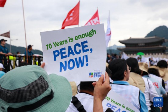 7月22日，在韓國首爾，人們手舉標(biāo)語參與反戰(zhàn)游行。新華社發(fā)（楊暢 攝）