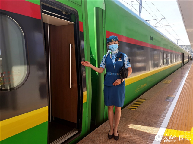 趙瑩靜站在“復(fù)興號”國際旅客列車車廂門口歡迎旅客上車。人民網(wǎng) 杜明明攝