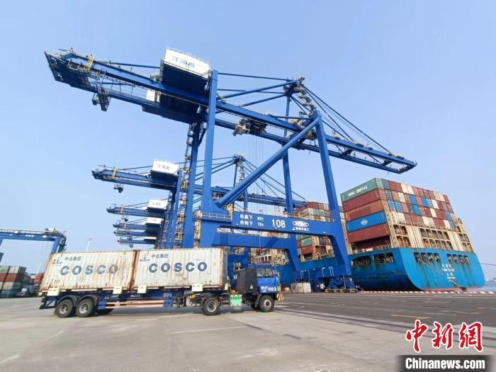 圖為海南洋浦國際集裝箱碼頭，卡車將集裝箱從后方堆場運往碼頭裝卸區(qū)?！堅潞?攝