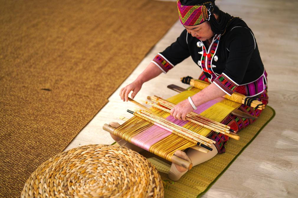 4月17日，黎族傳統(tǒng)紡染織繡技藝國(guó)家級(jí)代表性傳承人劉香蘭在2023年意大利米蘭設(shè)計(jì)周上展示黎錦織造技藝。新華社發(fā)