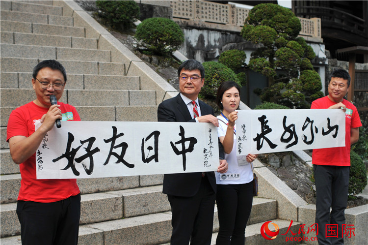 東京中國(guó)文化中心主任羅玉泉展示其為本次活動(dòng)書寫的題詞“中日友好，山高水長(zhǎng)”。人民網(wǎng) 蔣曉辰攝
