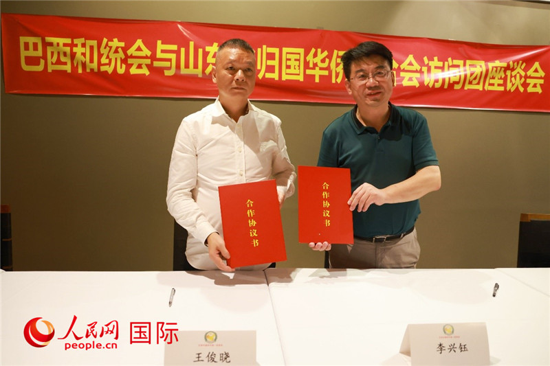 中國僑聯(lián)副主席、山東省僑聯(lián)主席李興鈺（右）與巴西和統(tǒng)會會長王俊曉簽署合作協(xié)議書。人民網(wǎng)記者 陳海琪攝