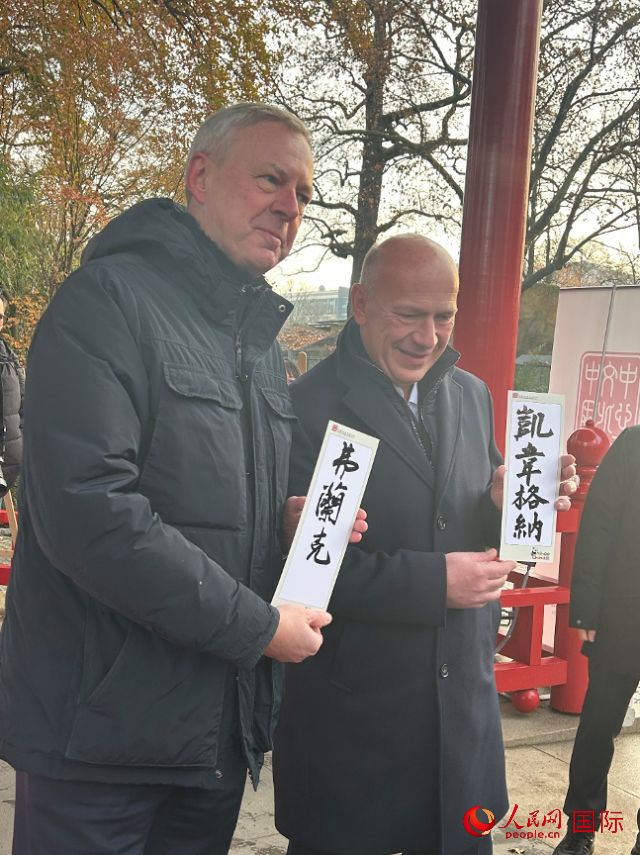 柏林市長韋格納（右）、動物園監(jiān)事會主席布魯克曼（左）手持中國文化中心工作人員現(xiàn)場手書的中文名字。人民網(wǎng)記者 徐馨攝