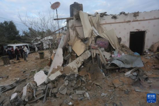 2月5日，在加沙地帶南部城市拉法，人們查看以軍空襲后的建筑廢墟。新華社發(fā)（哈立德·奧馬爾攝）