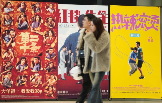 這是2月17日，在沈陽一家影院，觀眾從海報(bào)前經(jīng)過。新華社記者李鋼攝