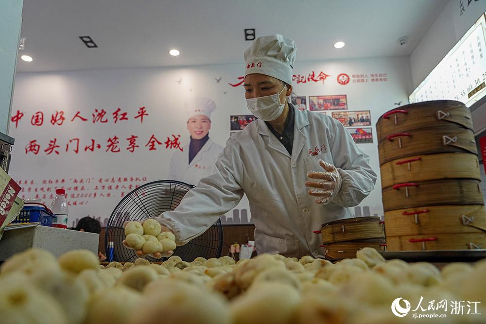 3月31日，在浙江省嵊州市甘霖鎮(zhèn)，嵊州小吃從業(yè)者沈紅平把蒸熟的小籠包晾涼，打包冷藏售賣。人民網(wǎng) 章勇濤攝