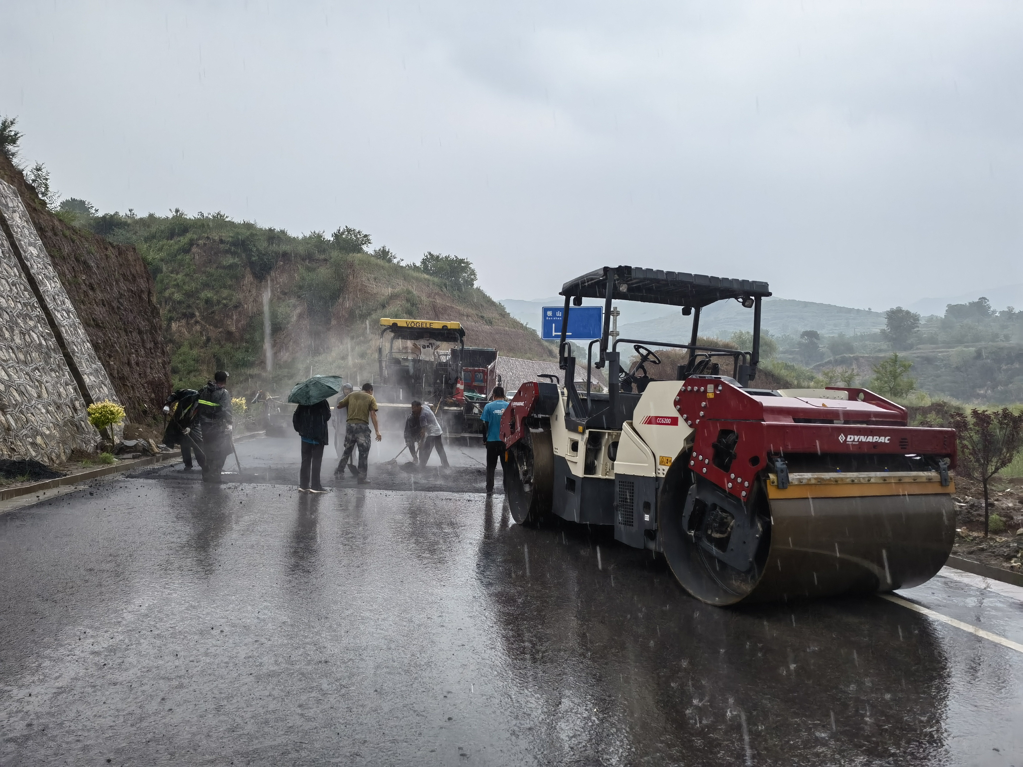 路橋工人在大雨中搶修道路。李華英 攝