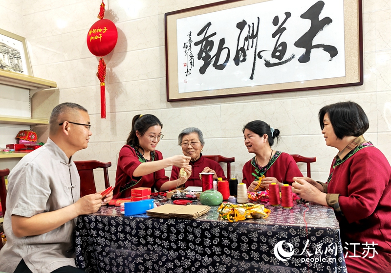 王秀英老人指導(dǎo)孫女制作香包。人民網(wǎng) 閆峰攝