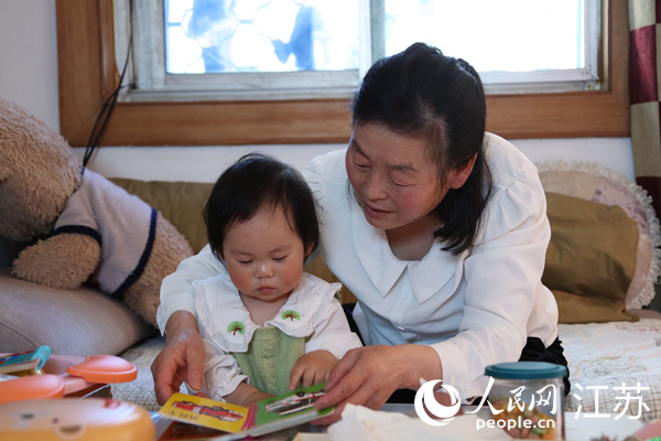 王繼蓮帶孫女看童書。人民網(wǎng) 冷金明攝