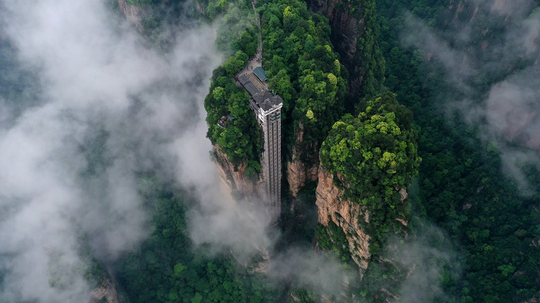 位于張家界武陵源景區(qū)的百龍?zhí)焯蓁偳对谠旗F繚繞的峰林間，雄偉壯觀。吳勇兵攝
