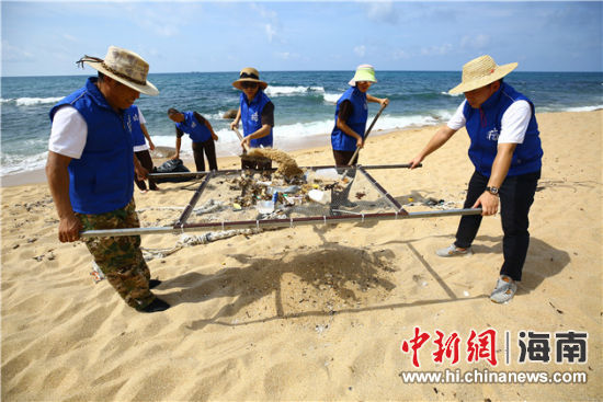環(huán)保志愿者用篩網(wǎng)“淘”出海灘上的垃圾。