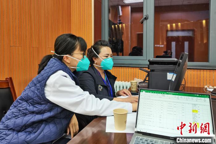 8月9日，楊蘇喬(左)在拉薩方艙醫(yī)院指揮部讀取艙內(nèi)患者胸部CT?！∈茉L者供圖