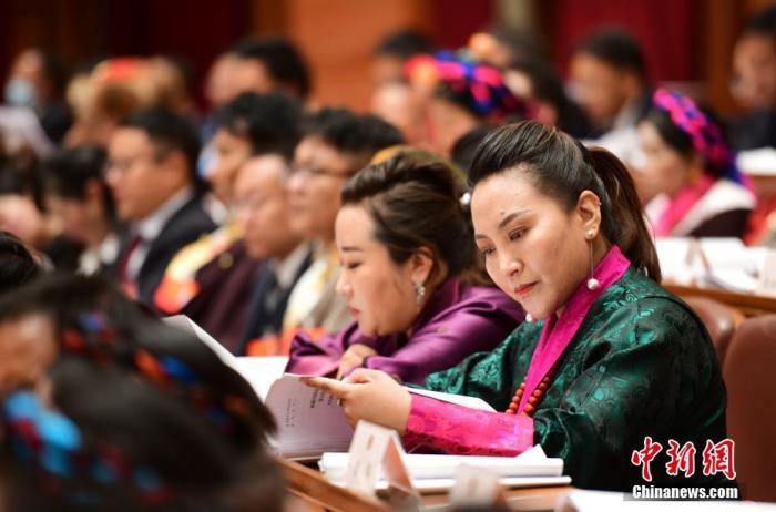 1月5日，次旦卓嘎(右一)在拉薩參加西藏自治區(qū)第十一屆人民代表大會第五次會議第二次全體會議。西藏自治區(qū)人大代表次旦卓嘎來自日喀則市定日縣，定日縣被稱為“洛諧故鄉(xiāng)”，作為西藏民間歌舞，洛諧已被列入中國國家非物質(zhì)文化遺產(chǎn)項目名錄，這是集歌、舞、樂、彈唱于一體的綜合藝術(shù)形式。參加完西藏2022年新年音樂會的次旦卓嘎告訴記者，每年參加的基層演出可達80場，“我希望用最純粹的方式，把最好的聲音帶到西藏乃至中國的各個角落?！?<a target='_blank' href='/'><p  align=
