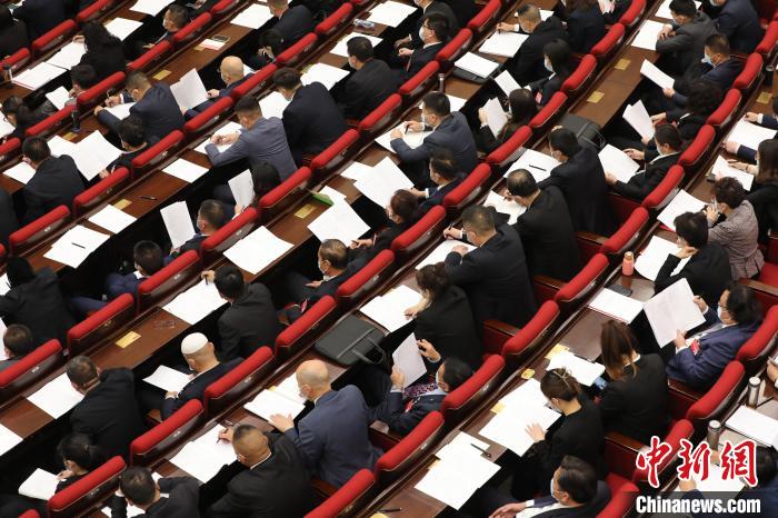 圖為會議現(xiàn)場，參會代表正在聽取政府工作報(bào)告?！∑钤鲚?攝