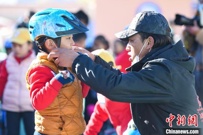 圖為拉薩市實驗幼兒園孩子在教練的幫助下穿戴頭盔?！『闻罾?攝