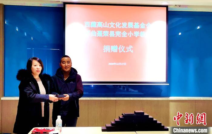 圖為西藏高山文化發(fā)展基金會(huì)理事長(zhǎng)溫麗向聶榮縣完全小學(xué)負(fù)責(zé)人捐助儀器。　于賓 攝
