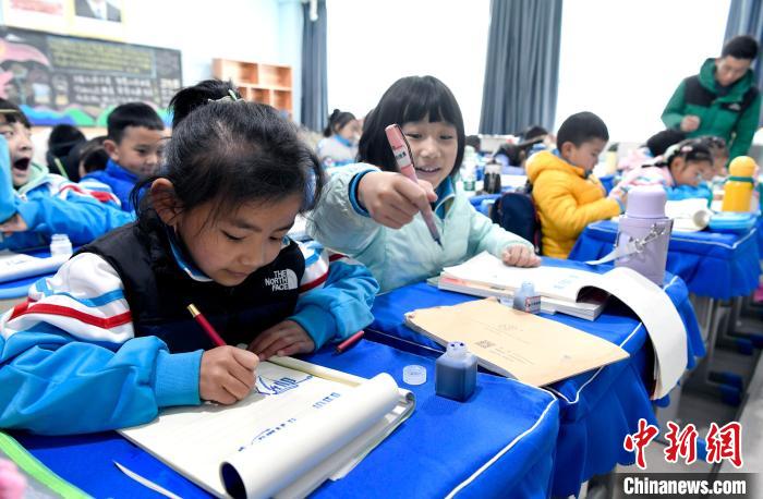 3月14日，西藏拉薩市第一小學(xué)一年級六班學(xué)生白瑪朗珍(圖左)在藏語文課上書寫藏文?！±盍?攝