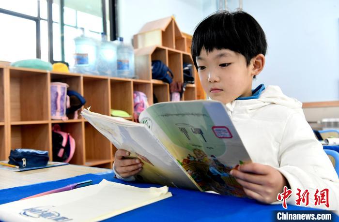 3月14日，西藏拉薩市第一小學(xué)一年級六班學(xué)生丁增樂吉在閱讀藏語課本?！±盍?攝