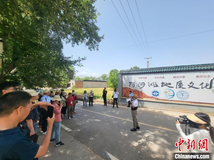 圖為中國地質(zhì)大學(xué)(北京)教授張緒教介紹村落情況?！『衍?攝