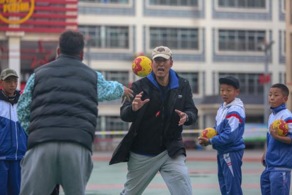 在高原上教孩子們打手球，“慢慢兒來，甭著急！”