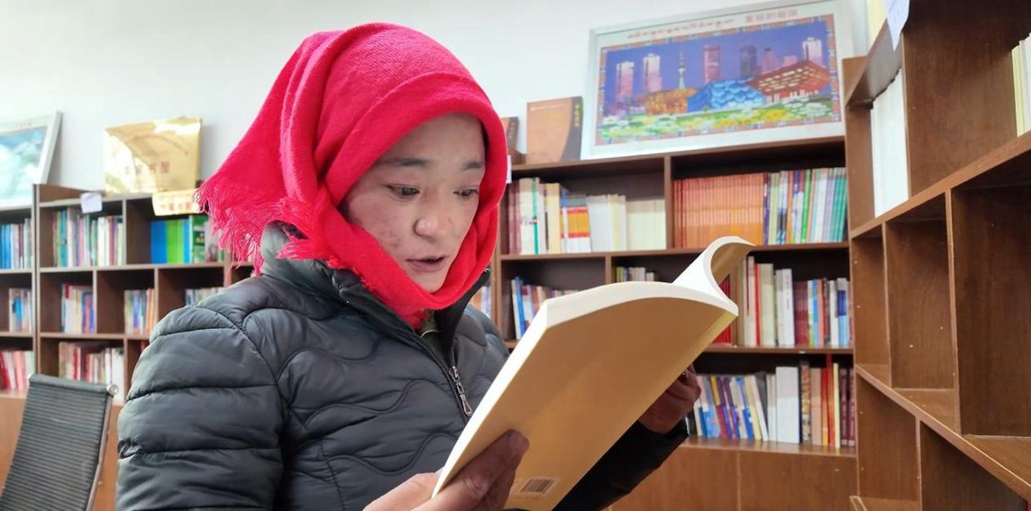 一名婦女正在認(rèn)真閱讀書(shū)籍。申扎縣融媒體中心供圖