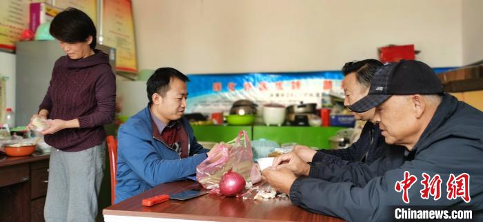 圖為扶貧路上“臨時一家人”準備午餐。　魏建軍 攝
