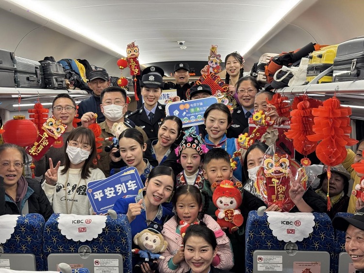 春節(jié)期間，在中老鐵路磨萬（磨丁—萬象）段，鐵路客運員工與乘客合影留念。李加勇攝