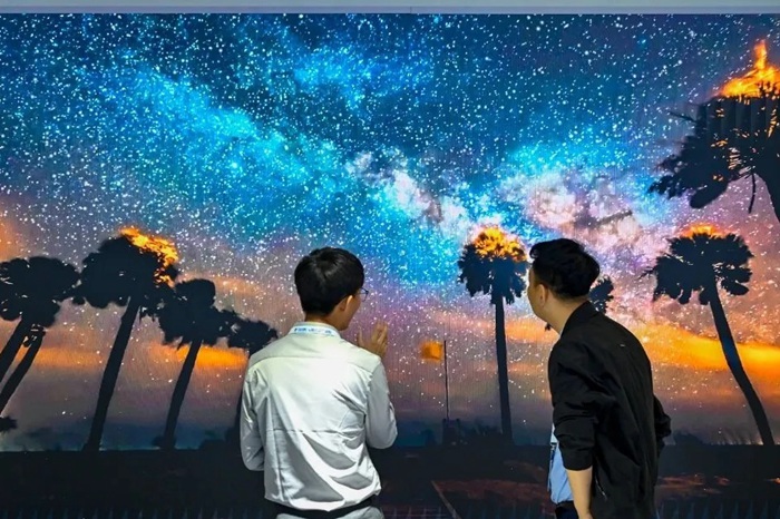長春光博會希達電子展區(qū)，一位工作人員正在給一位觀眾講解。（長春新區(qū)供圖）