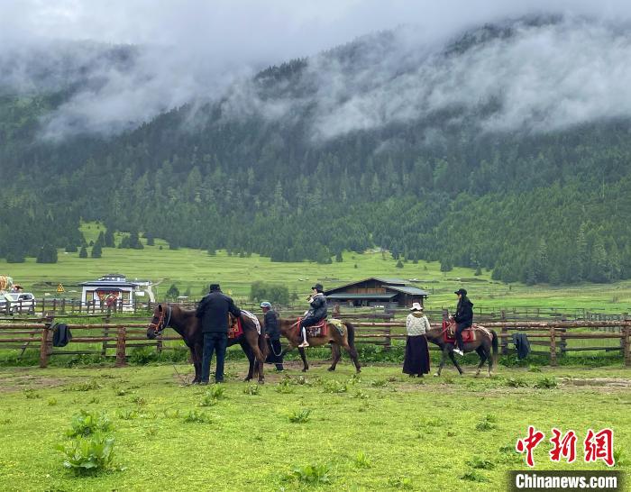 6月10日，游客在魯朗小鎮(zhèn)高山牧場景區(qū)體驗騎馬?！∪轿木?攝