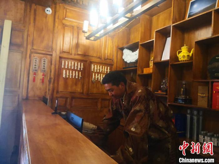 圖為桑杰才讓用電腦處理財(cái)務(wù)?！∈缝o靜 攝