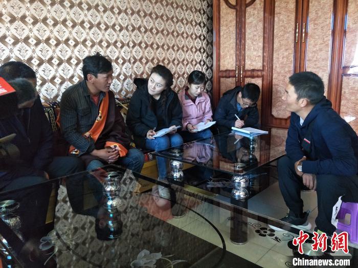 圖為調(diào)查組工作人員正在入戶調(diào)查?！∑钤鲚?攝