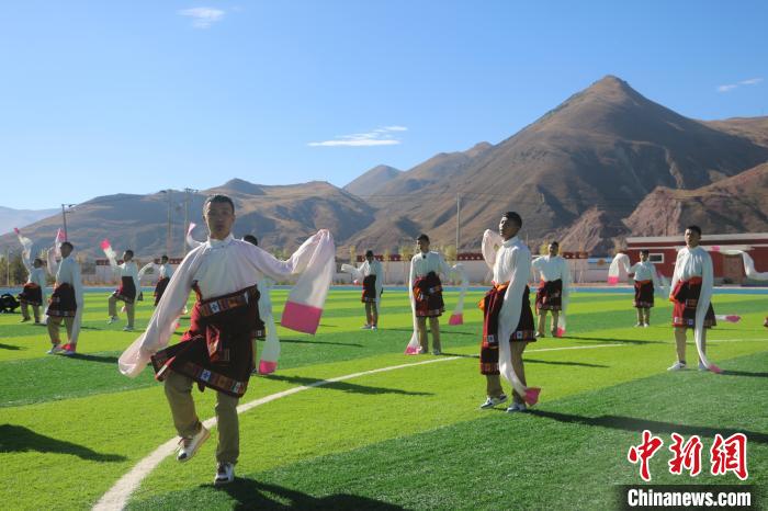 圖為青海師范大學(xué)附屬玉樹實(shí)驗(yàn)學(xué)校學(xué)生在綠茵場(chǎng)跳起囊謙古舞—卓根瑪。　程雨 攝