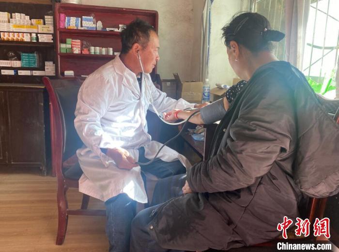 索木滾(左)為村民看病?！∪捞量h委宣傳部供圖