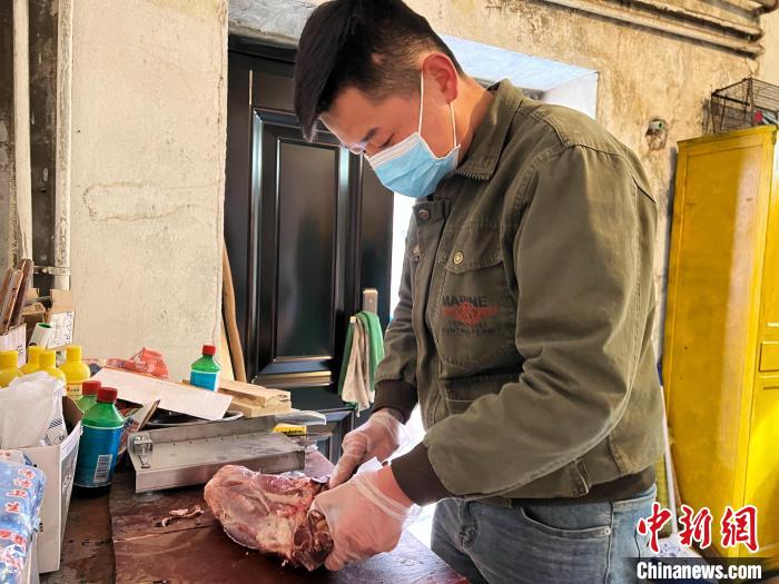 圖為雪豹“奶爸”史壽軍正在準(zhǔn)備投喂雪豹的食材?！●R銘言 攝