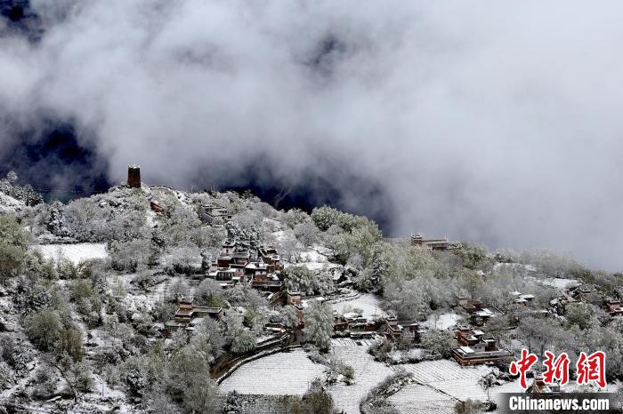 雪后的藏寨和碉樓構(gòu)成美麗的雪景?！〗党鯘衫?攝