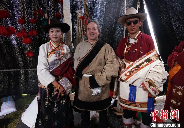 圖為一名外籍?dāng)z影師(中)身穿藏服和藏族民眾合影留念?！●R銘言 攝