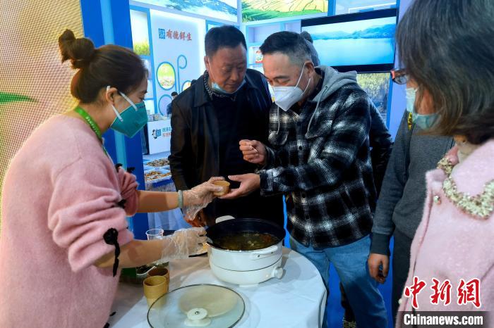 圖為杭州市民品嘗茶卡羊肉?！±铍h 攝